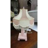 An art deco table lamp in shades of pink, complete with shade.