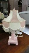 An art deco table lamp in shades of pink, complete with shade.