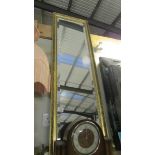 A tall gilt framed bevel edged mirror.