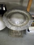 A reconstituted stone bird bath