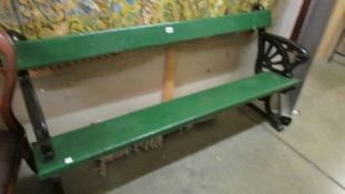 A heavy cast iron and timber bench (painted green and black), 138 cm long,