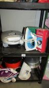 A mixed lot of household items including irons, grill, pressure cooker.