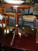 A darkwood stained tripod pub table