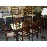 A dark oak draw leaf table with 8 matching ladder back chairs.