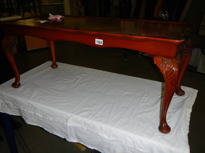 A dark wood stained long coffee table.