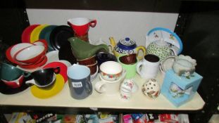 A mixed lot of cups, bowls, teapots etc., including colourful melamine.