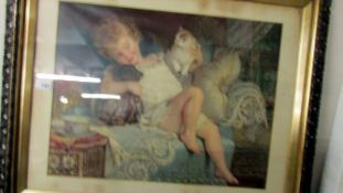 A large framed and glazed print of a child with cat and dog.