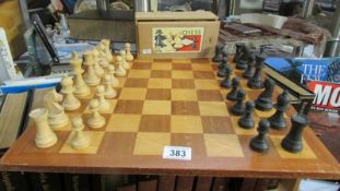 A chess board and chess set, missing black queen.