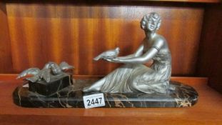 An art deco girl with birds on marble base.