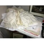 A quantity of misc. linen, includes table clothes, material, net curtain, vintage baby clothes etc.