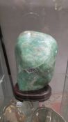 A heavy green stone sculpture on base.