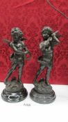 A pair of Bronze cherub musicians on marble bases, signed but indistinct.