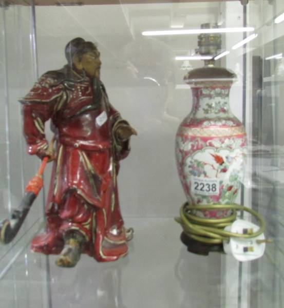 A Chinese figure and a Chinese lamp base.