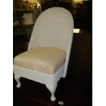 A lloyd loom style side chair with spring upholstered seat