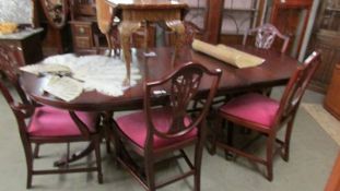 An oval mahogany extending dining table with one leaf together with a set of 6 shield back dining