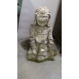 An old garden figure of a seated girl.