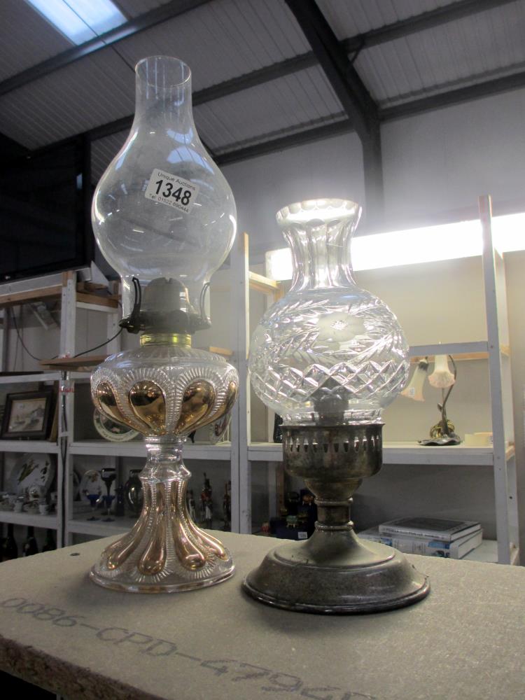 A silver plated candle lamp and a gilded glass oil lamp