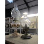 A silver plated candle lamp and a gilded glass oil lamp