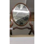 A bevel edged mahogany framed oval toilet mirror.