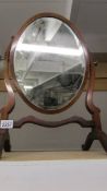 A bevel edged mahogany framed oval toilet mirror.