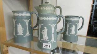 A set of 3 graduated Jasper style jugs together with a coffee pot with Jasper style applied cherubs,