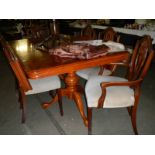 A dark wood stained extending dining table with 2 leaves and 6 chairs.