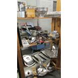 4 shelves of assorted kitchen ware including stainless steel.