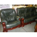 A green leather 3 seat sofa and chair with dark wood frames.