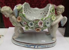 A 20th century table centrepiece being two cherubs supporting a floral decorated bowl.