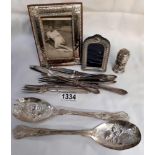 An assortment of cutlery and 2 picture frames