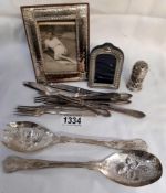 An assortment of cutlery and 2 picture frames