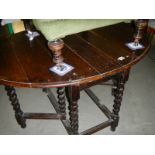A Victorian oak gate leg table on barley twist legs.