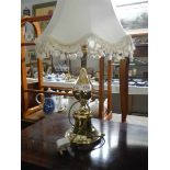 A brass effect table lamp with shade