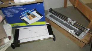 A boxed guillotine and a tile cutter.