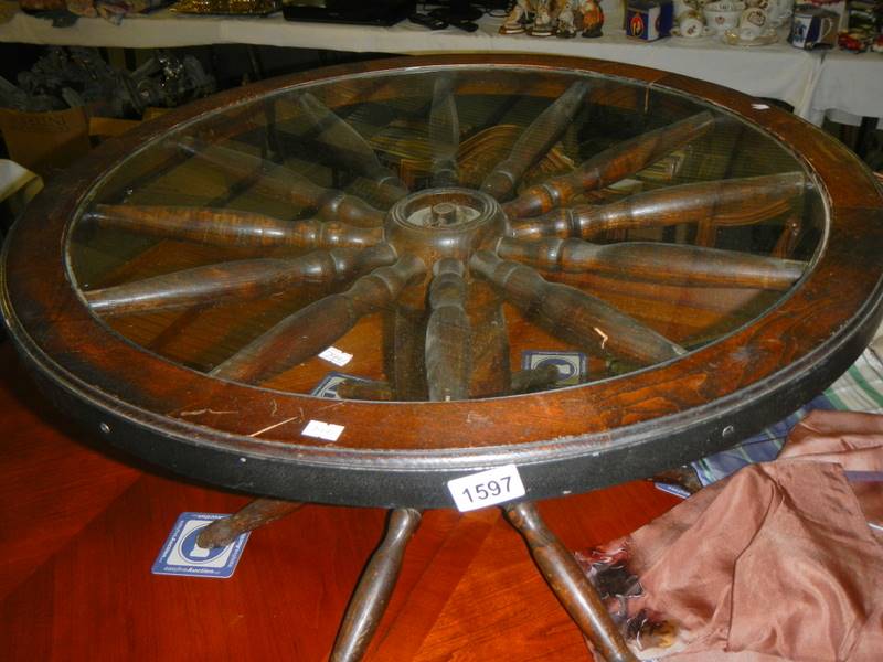 A cartwheel style coffee table with glass top.