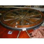 A cartwheel style coffee table with glass top.