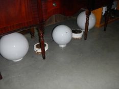 2 large and one smaller white glass globes with some metal ceiling roses.