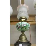 A brass oil lamp with hand painted glass font and later shade.