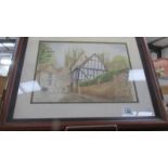 A framed and glazed village scene signed Janet Nichols '98.