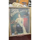 A framed and glazed Coca Cola advertisement.