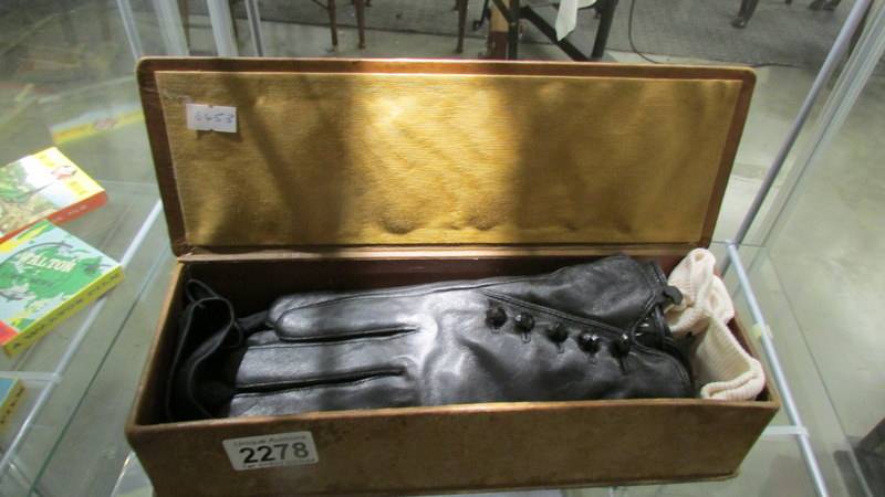 An old glove box and 3 pairs of vintage gloves.