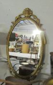 An oval metal framed mirror.