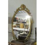 An oval metal framed mirror.