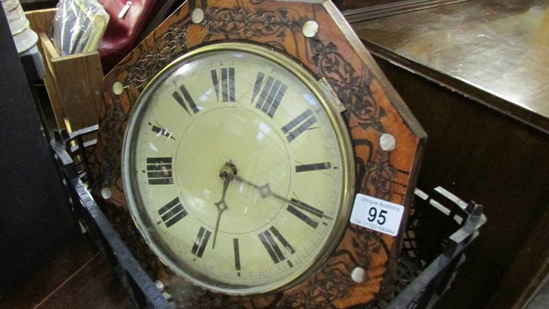 A wall clock with brass weights.