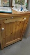 A pine single door cupboard.