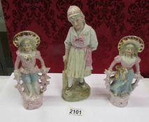 A pair of continental bisque figurines and one other.