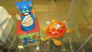 A tin plate Mobo tortoise and a tin plate Tom and Jerry Jack in the box.