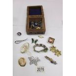 A wooden box containing a Scottish agate bracelet, cameo brooch, other brooches and badges.