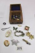 A wooden box containing a Scottish agate bracelet, cameo brooch, other brooches and badges.