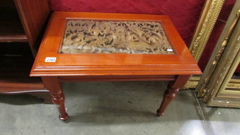 A coffee table with intricately carved inset.